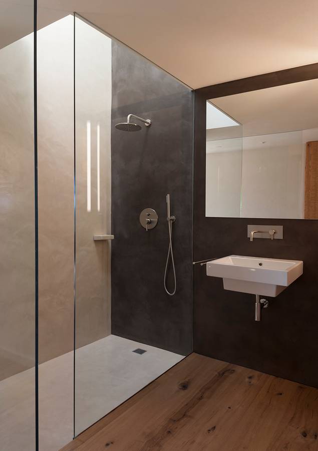 Parets i plat de dutxa recoberts amb ciment polit en dues tonalitats cromàtiques diferents